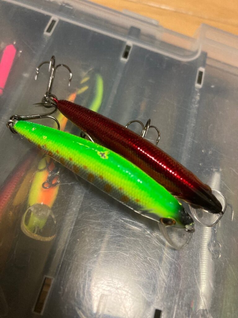 赤と緑のカスタムルアーが釣り用ボックスに並べられている画像