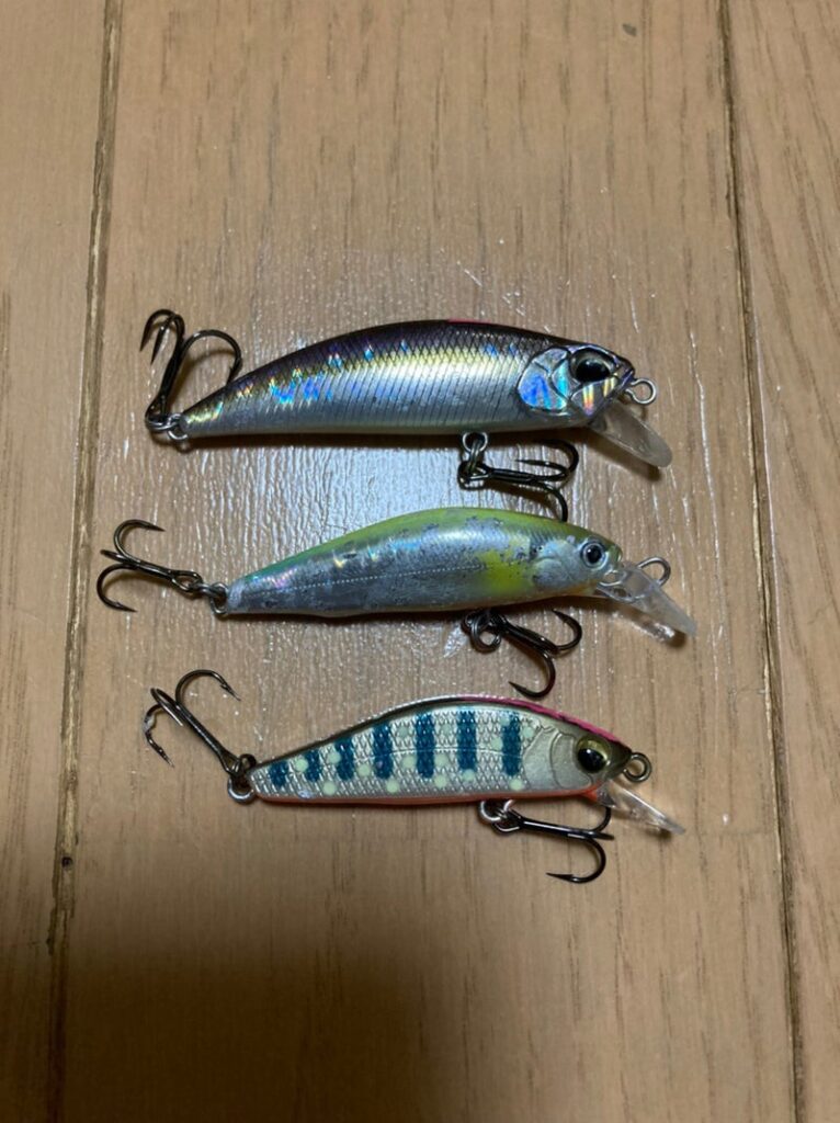 3種類のカスタムルアーが木の床の上に並べられています。