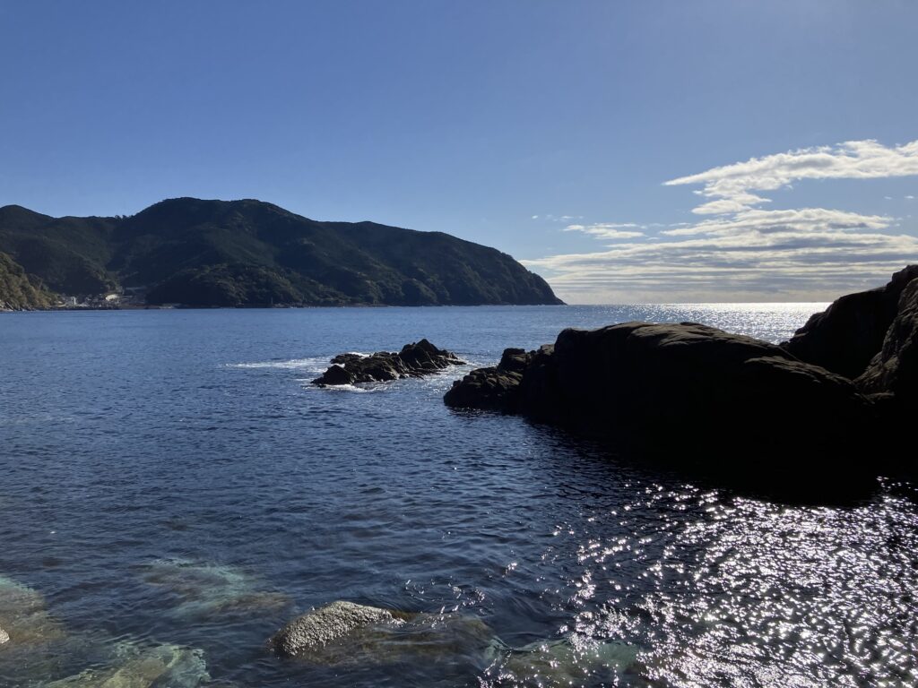 美しい海と青空が広がる風景、遠くには山々が見える