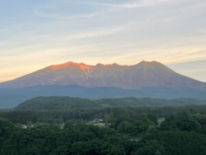 開田高原から望む、朝焼けに映える7月の御嶽山。谷筋には若干の雪が残る。